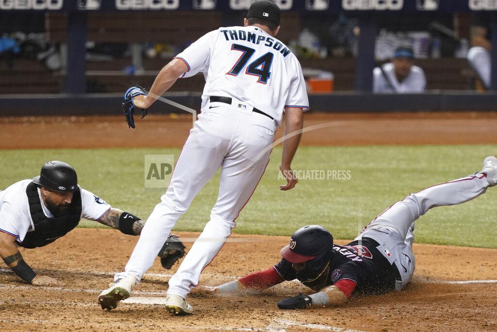 Marta Lavandier Miami Marlins' catcher Sandy Leon, left, stretches to tag Washington Nationals' Carter Kieboom (8) who was trying to score on a wild pitch while Marlins relief pitcher Zach Thompson (74) stands between them during the seventh inning of a baseball game, Monday, Sept. 20, 2021, in Miami. (AP Photo/Marta Lavandier)