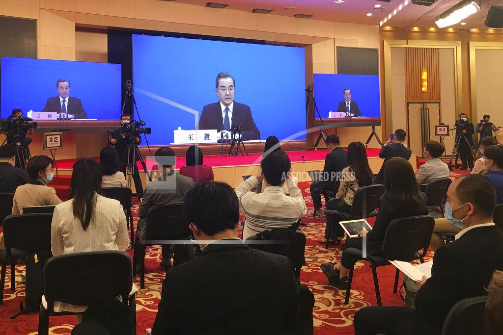 Ken Moritsugu China's Foreign Minister Wang Yi is seen broadcasted remotely on big screens at the media center during a press conference held on the sideline of the National People's Congress in Beijing on Sunday, May 24, 2020. (AP Photo/Ken Moritsugu)