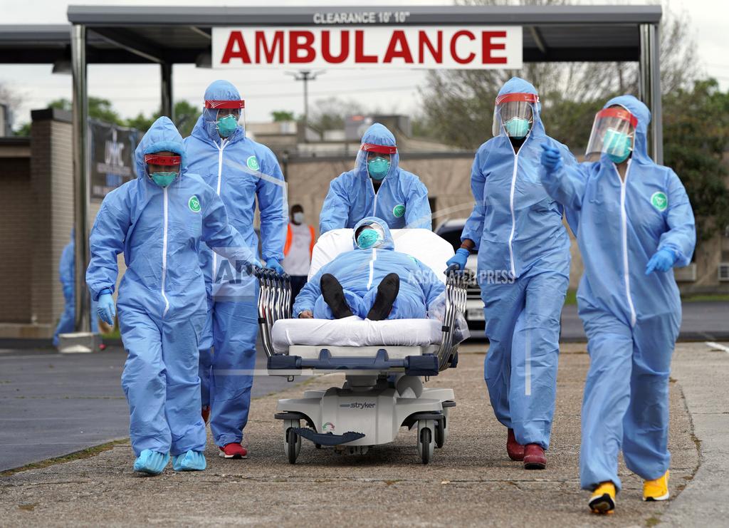 David J. Phillip FILE - In this Thursday, March 19, 2020 file photo, a patient is taken on a stretcher into the United Memorial Medical Center after going through testing for COVID-19 in Houston. People were lined up in their cars in a line that stretched over two miles to be tested in the drive-thru testing for coronavirus. (AP Photo/David J. Phillip, File)