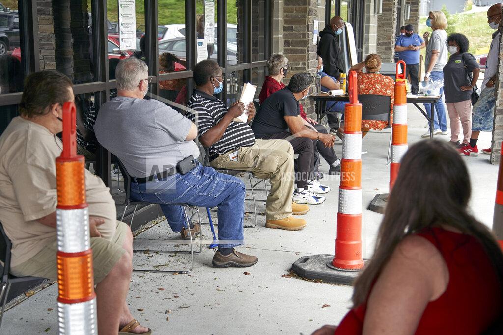 Nati Harnik FILE - In this July 15, 2020, file photo, job seekers exercise social distancing as they wait to be called into the Heartland Workforce Solutions office in Omaha, Neb. With an influx of federal stimulus money coming on top of surprisingly strong revenue pictures, governors suddenly have a way to pay for big, expensive undertakings that have long languished on their to-do lists. (AP Photo/Nati Harnik, File)