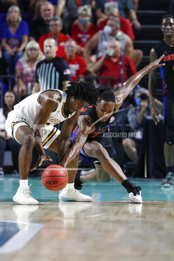 Scott Audette California guard Joel Brown (1) and Florida guard Phlandrous Fleming Jr. (24) reach for a loose ball during the first half of an NCAA college basketball game Monday, Nov. 22, 2021, in Fort Myers, Fla. (AP Photo/Scott Audette)