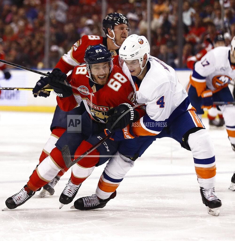 Brynn Anderson Florida Panthers left wing Mike Hoffman (68) and New York Islanders defenseman Thomas Hickey (4) fight for the puck during the second period of an NHL hockey game on Thursday, April 4, 2019, in Sunrise, Fla. (AP Photo/Brynn Anderson)