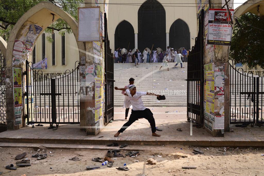 Mahmud Hossain Opu A group of protestors pelt stones on another after Friday prayers at Baitul Mokarram mosque in Dhaka, Bangladesh, Friday, March 26, 2021. Witnesses said violent clashes broke out after one faction of protesters began waving their shoes as a sign of disrespect to Indian Prime Minister Narendra Modi, and another group tried to stop them. Local media said the protesters who tried to stop the shoe-waving are aligned with the ruling Awami League party. The party criticized the other protest faction for attempting to create chaos in the country during Modi’s visit. (AP Photo/Mahmud Hossain Opu)