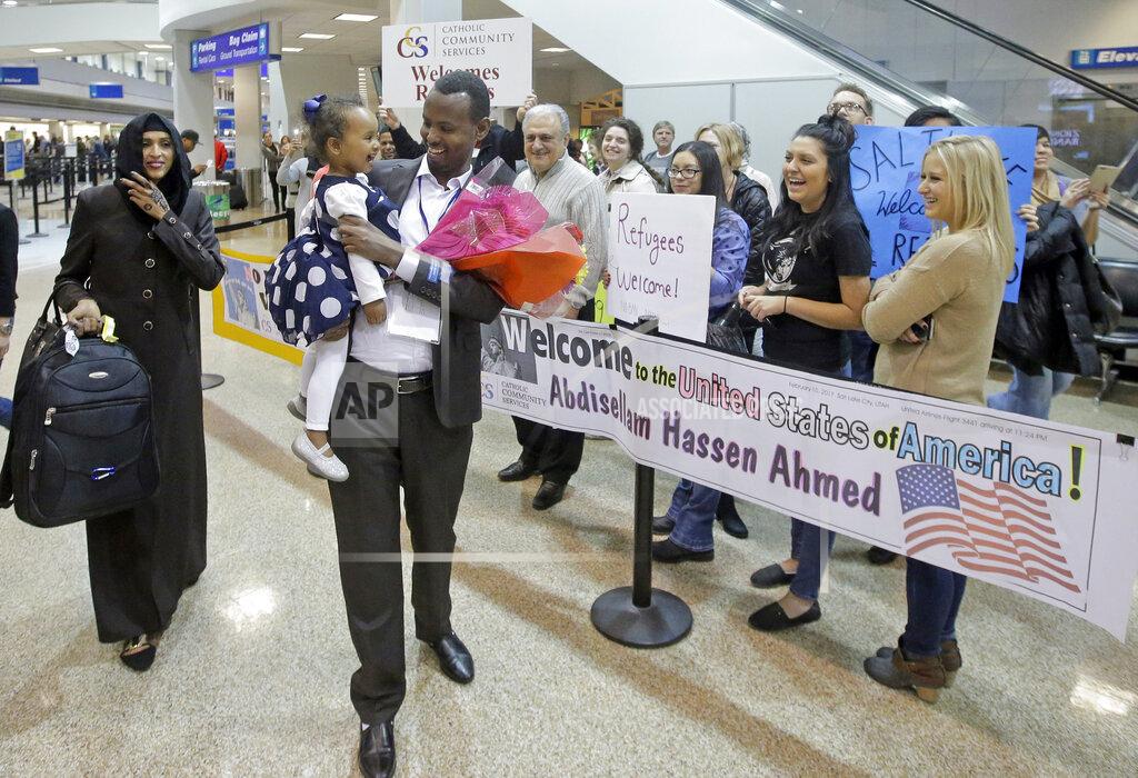FILE - This Feb. 10, 2017, file photo, Abdisellam Hassen Ahmed, a Somali refugee who had been stuck in limbo after President Donald Trump temporarily banned refugee entries, walks with his wife Nimo Hashi, and his 2-year-old daughter, Taslim, who he met for the first time after arriving at Salt Lake City International Airport. Refugee advocates, including faith-based groups that President Donald Trump is courting in his re-election bid, called on Congress Thursday, Oct. 1, 2020, to halt his administration’s plans to slash the limit on refugees allowed into the U.S. to a record low, saying it goes against America’s values. (AP Photo/Rick Bowmer, File)