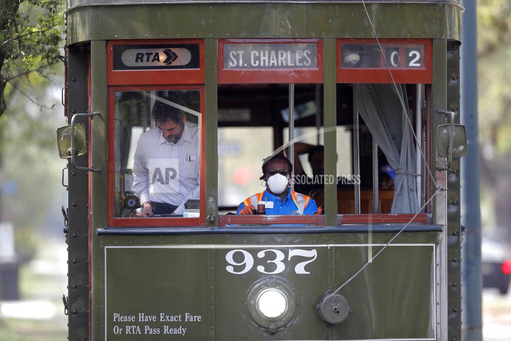Gerald Herbert FILE - In this March 19, 2020 file photo, a streetcar conductor wears a mask due to the coronavirus pandemic as she runs her route on St. Charles Ave. in New Orleans. Where political divides marred early recovery efforts after Hurricane Katrina in 2005, Louisiana is showing rare political unity in the fight against the new coronavirus. (AP Photo/Gerald Herbert, File)