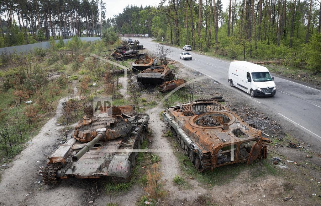 Efrem Lukatsky Cars pass by destroyed Russian tanks in a recent battle against Ukrainians in the village of Dmytrivka, close to Kyiv, Ukraine, Monday, May 23, 2022. No matter where Ukrainians live, the 3-month-old war never seems to be far away. Those in towns and villages near the front lines hide in basements from constant shelling, struggling to survive with no electricity or gas — and often no running water. (AP Photo/Efrem Lukatsky)