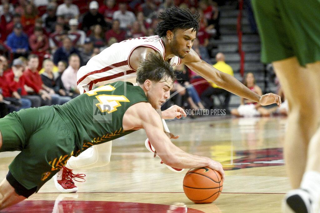 Michael Woods North Dakota State guard Boden Skunberg (14) and Arkansas guard Ricky Council IV, top, dive after the ball during the second half of an NCAA college basketball game Monday, Nov. 7, 2022, in Fayetteville, Ark. (AP Photo/Michael Woods)
