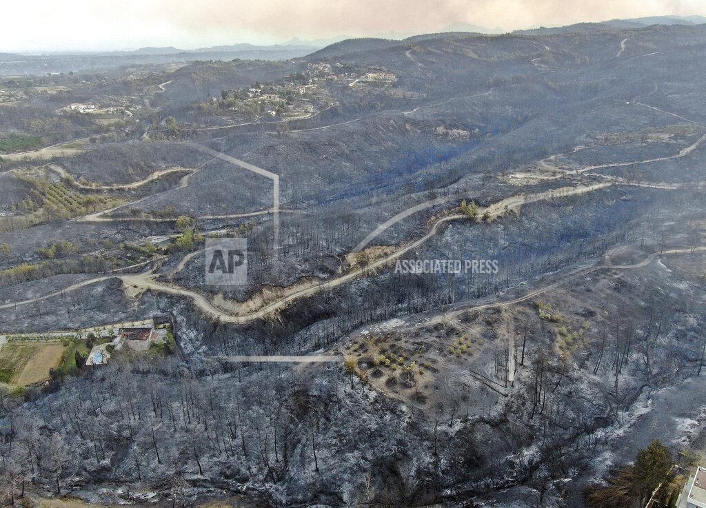 Suat Metin An aerial photo shows destroyed houses in a village as wildfire continue to rage the forests near the Mediterranean coastal town of Manavgat, Antalya, Turkey, Thursday, July 29, 2021. Authorities evacuated homes in southern Turkey as a wildfire fanned by strong winds raged through a forest area near the Mediterranean coastal town of Manavgat. District governor Mustafa Yigit said residents of four neighborhoods were moved out of the fire’s path as firefighters worked to control the blaze that broke out Wednesday. It was not immediately clear what caused the fire but authorities said nearby tourist resorts were not affected. (Suat Metin/IHA via AP)