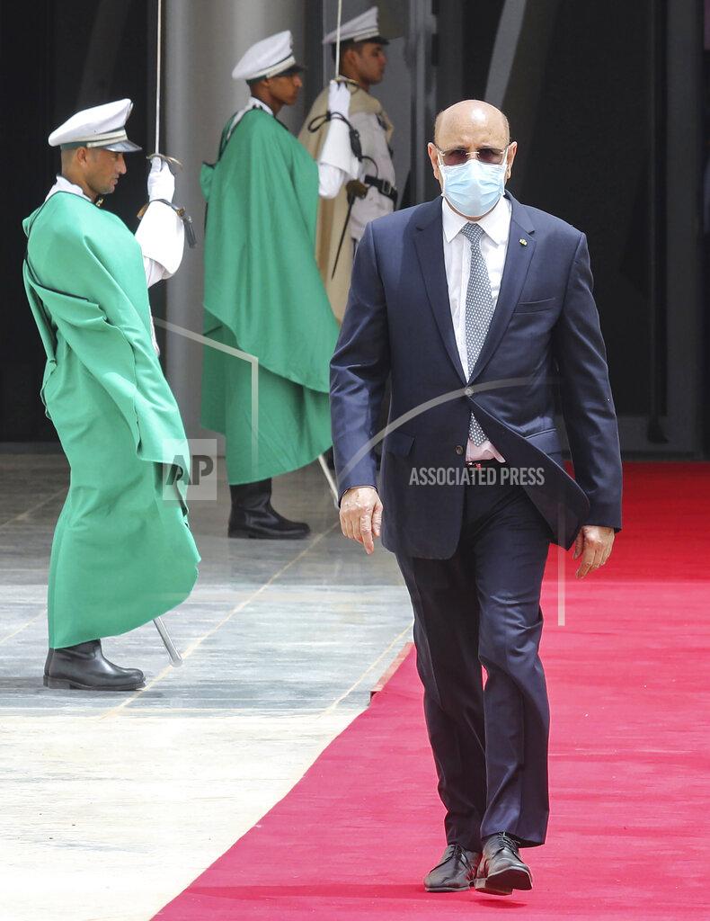 Ludovic Marin Mauritanian President Mohamed Ould Ghazouani wears a face mask as he walks past a guard of honor to welcome the French president upon arrival at Nouakchott Oumtounsy International Airport Tuesday June 30, 2020, in Nouakchott, to attend a G5 Sahel summit. Leaders from the five countries of West Africa's Sahel region, Burkina Faso, Chad, Mali, Mauritania and Niger, meet with French President Emmanuel Macron and Spanish Prime Minister Pedro Sanchez in Mauritania's capital Nouakchott on Tuesday to discuss military operations against Islamic extremists in the region, as jihadist attacks mount. The five African countries, known as the G5, have formed a joint military force that is working with France, which has thousands of troops to battle the extremists in the Sahel, the region south of the Sahara Desert. (Ludovic Marin, Pool via AP)