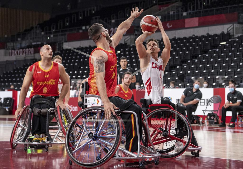 Bob Martin Nikola Concin of Canada shoots marked by Manuel Lorenzo Diaz, center, of Spain during the men's wheelchair basketball Group A game at the Tokyo 2020 Paralympic Games in Tokyo Thursday, Aug. 26, 2021. (Bob Martin for OIS via AP)