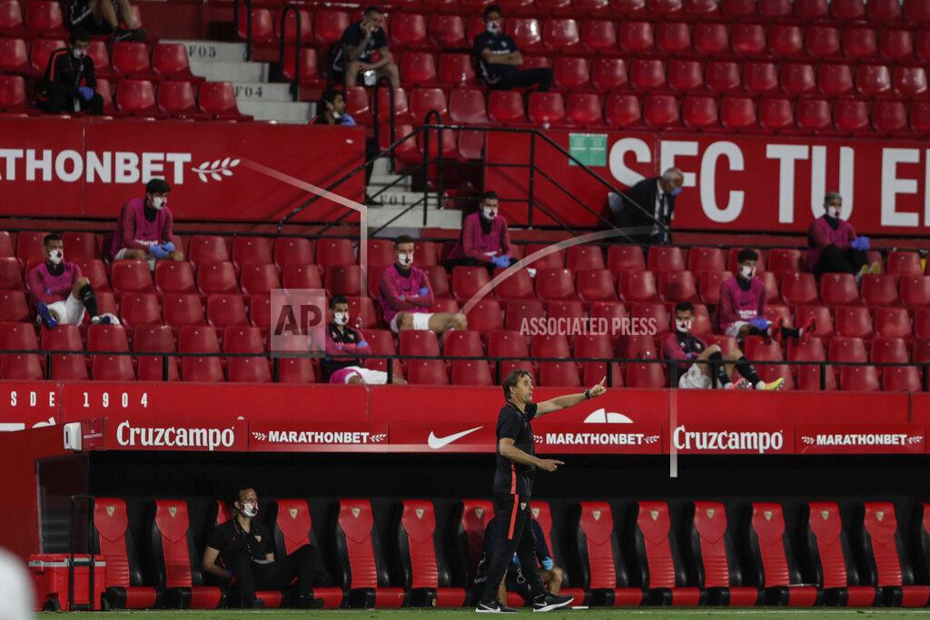 Str Sevilla's head coach Julen Lopetegui, center and bottom, gestures during the Spanish La Liga soccer match between Sevilla and Betis in Seville, Spain, Thursday, June 11, 2020. With virtual crowds, daily matches and lots of testing for the coronavirus, soccer is coming back to Spain. The Spanish league resumes this week more than three months after it was suspended because of the pandemic, becoming the second top league to restart in Europe. The Bundesliga was first. The Premier League and the Italian league should be next in the coming weeks. (AP Photo)