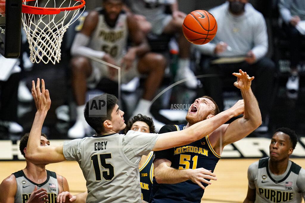Michael Conroy Purdue center Zach Edey (15) fouls Michigan forward Austin Davis (51) during the first half of an NCAA college basketball game in West Lafayette, Ind., Friday, Jan. 22, 2021. (AP Photo/Michael Conroy)