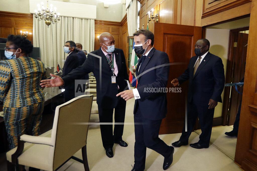 Themba Hadebe South African President Cyril Ramaphosa, right, and his French counterpart Emmanuel Macron, center, arrive for a meeting, at the government's Union Buildings, in Pretoria, South Africa, Friday, May 28, 2021. Macron is on a two-day official visit to the country. (AP Photo/Themba Hadebe, Pool)