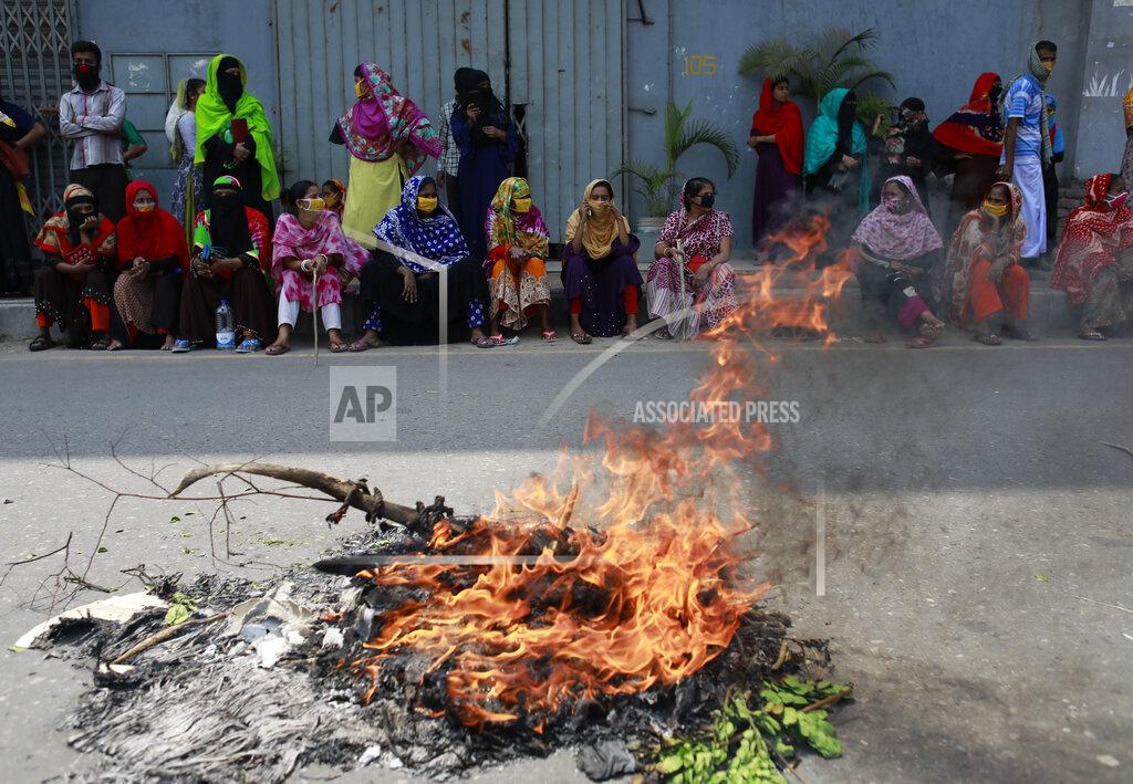 Al-Emrun Garjon Bangladeshi garment workers sit beside a fire demanding their unpaid wages during a protest in Dhaka, Bangladesh, Thursday, April 16, 2020. Hundreds of Bangladeshi workers who produce garments for global brands protested in Dhaka and blocked a highway outside the capital on Thursday to demand unpaid wages during a nationwide lockdown that has forced most factories to suspend operations. (AP Photo/Al-emrun Garjon)