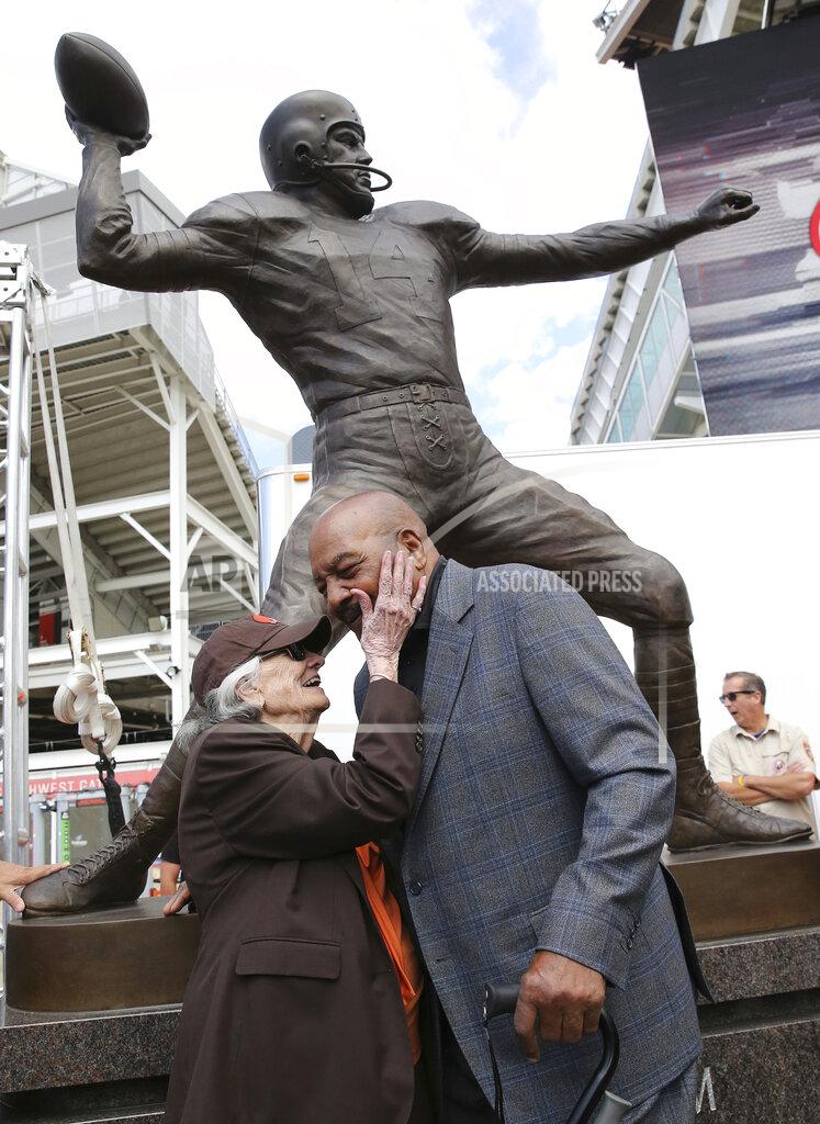 Beverly Graham warmly greets former Cleveland Browns running back Jim Brown in front of the bronze statue of Beverly's husband, former Browns quarterback great Otto Graham, after the Browns' unveiling ceremony, Saturday, Sept. 7, 2019, at FirstEnergy Stadium in Cleveland, Ohio. Graham's remarkable decade of dominance with the Browns has been immortalized. The team unveiled a bronze statue on Saturday, Sept. 7, 2019, outside FirstEnergy Stadium of the late Hall of Fame quarterback, who led Cleveland to 10 championship games in 10 seasons. (John Kuntz/cleveland.com via AP)