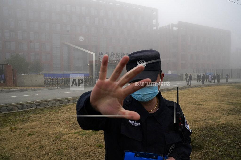 Ng Han Guan A security person moves journalists away from the Wuhan Institute of Virology after a World Health Organization team arrived for a field visit in Wuhan in China's Hubei province on Wednesday, Feb. 3, 2021. The WHO team is investigating the origins of the coronavirus pandemic has visited two disease control centers in the province. (AP Photo/Ng Han Guan)