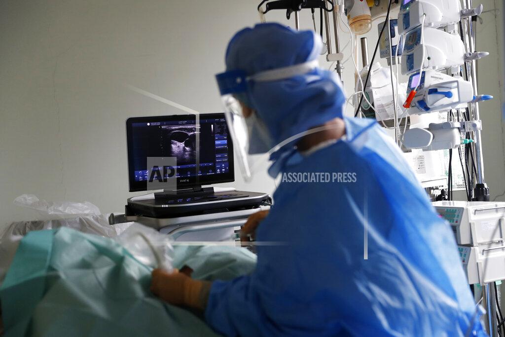Armando Franca A doctor performs an ultrasound scan on a patient in a COVID-19 Intensive Care Unit at the Curry Cabral hospital in Lisbon, Thursday, Feb. 11, 2021. After Portugal figured for about two weeks last month as the world’s worst-hit country by size of population, anxiety over the recent pandemic peak has eased slightly. The number of COVID-19 patients in hospital and in intensive care fell Thursday for the third straight day. The health ministry reported the fewest hospitalizations since Jan. 20 and the fewest patients in ICUs for almost two weeks. (AP Photo/Armando Franca)