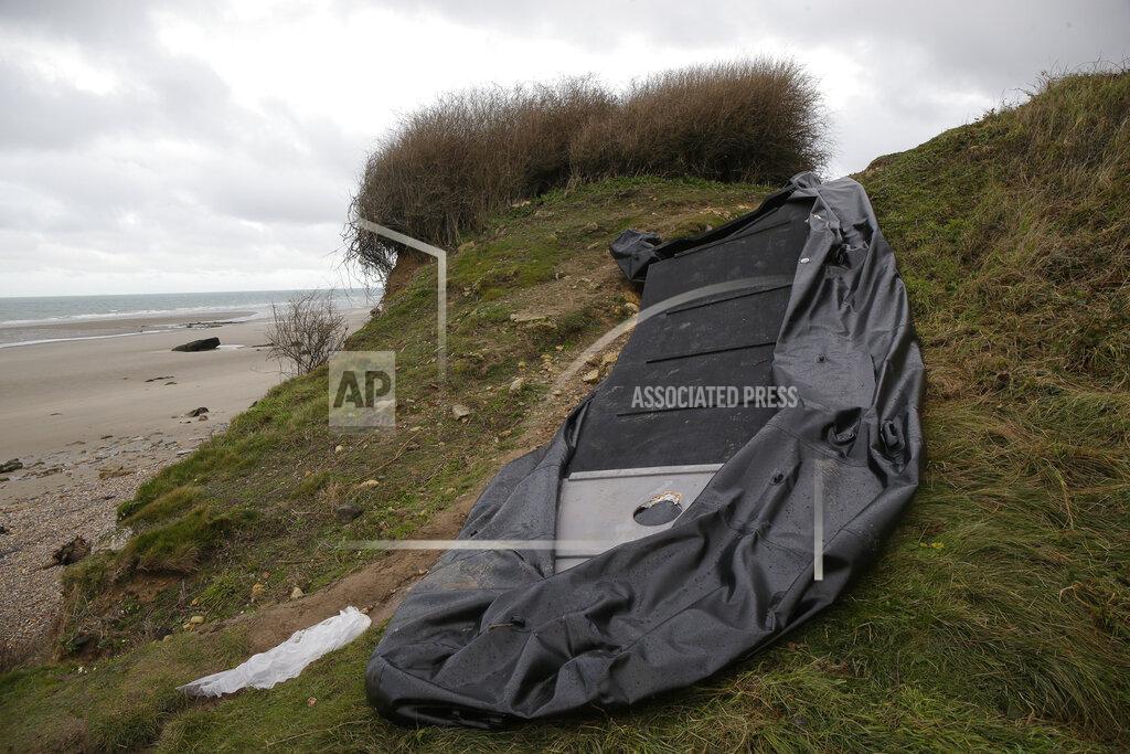Michel Spingler A damaged inflatable small boat is pictured on the shore in Wimereux, northern France, Thursday, Nov. 25, 2021 in Calais, northern France. Children and pregnant women were among at least 27 migrants who died when their small boat sank in an attempted crossing of the English Channel, a French government official said Thursday. French Interior Minister Gerald Darmanin also announced the arrest of a fifth suspected smuggler thought to have been involved in what was the deadliest migration tragedy to date on the dangerous sea lane.(AP Photo/Michel Spingler)