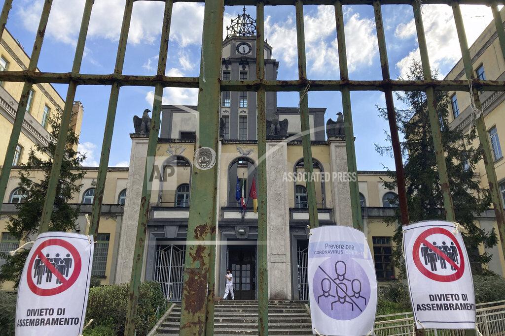 Gregorio Borgia Signs reading in Italian "No gathering" hang from a closed gate of the Cesare Battisti primary school, in Rome, Thursday, March 4, 2021. The first anti-pandemic decree from Italy's new premier, Mario Draghi, tightens measures governing school attendance while easing restrictions on museums, theaters and cinemas. (AP Photo/Gregorio Borgia)