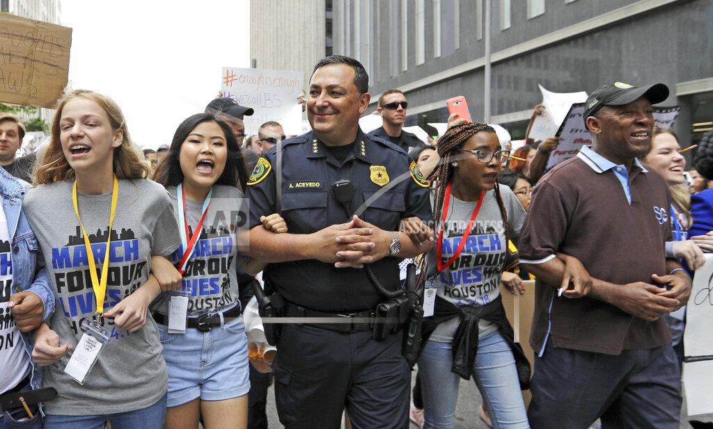 David J. Phillip FILE - Houston Police Chief Art Acevedo, center, and Houston Mayor Sylvester Turner, far right, join demonstrators during a "March for Our Lives" protest for gun legislation and school safety Saturday, March 24, 2018, in Houston. The National Rifle Association is going ahead with its annual meeting in Houston just days after the shooting massacre at a Texas elementary school that left 19 children and 2 teachers dead. With protests planned outside, former President Donald Trump and other leading GOP figures, including South Dakota Gov. Kristi Noem, will address attendees. (AP Photo/David J. Phillip, File)