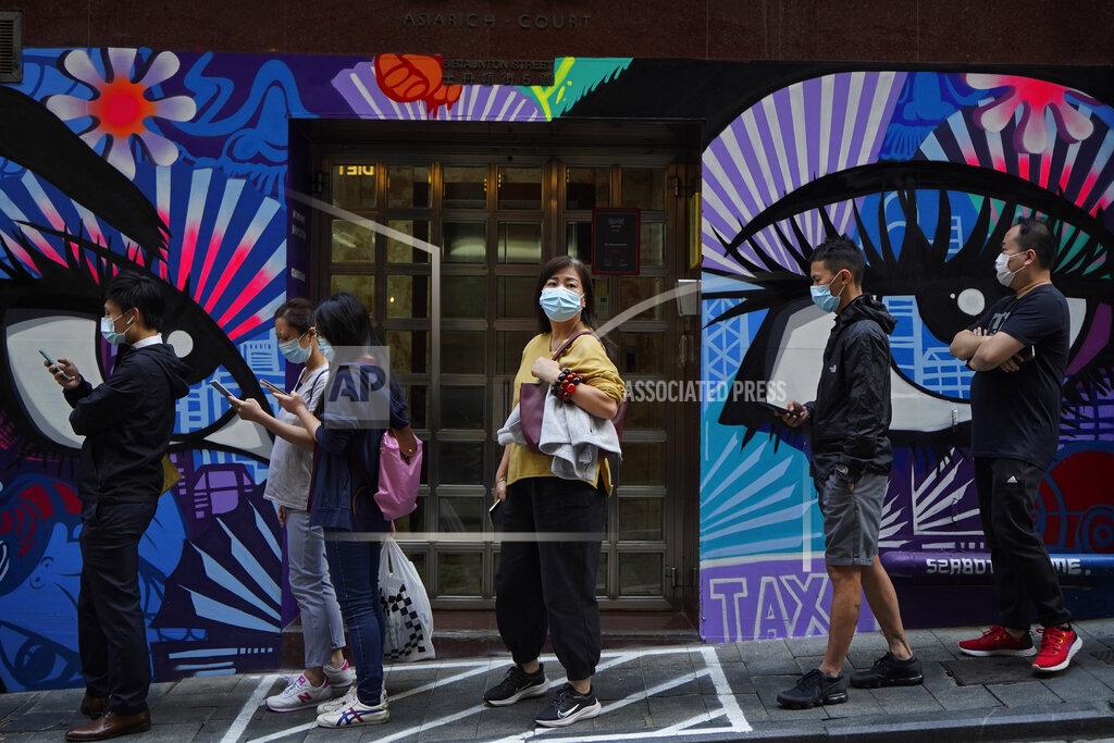 Kin Cheung People wearing face masks to help curb the spread of the coronavirus wait outside a bakery in Hong Kong, Monday, Nov. 30, 2020. (AP Photo/Kin Cheung)
