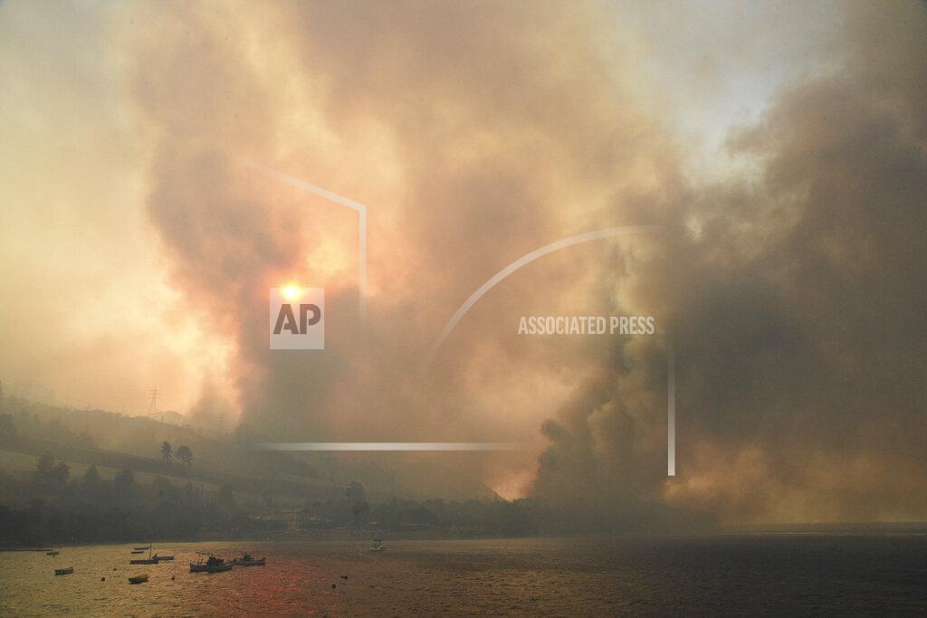 Andreas Alexopoulos Smoke rises during a wildfire near Lampiri village, west of Patras, Greece, Saturday, Jul. 31, 2021. The fire, which started high up on a mountain slope, has moved dangerously close to seaside towns and the Fire Service has send a boat to help in a possible evacuation of people. (AP Photo/Andreas Alexopoulos)
