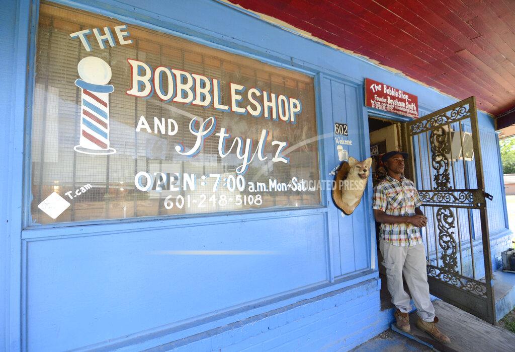 Barber Rayshaun Smith is pictured outside The Bobbleshop & Stylz barber shop in McComb, Miss., on Monday, May 11, 2020, as barbershops and salons reopened in the state. (Matt Williamson/Enterprise-Journal via AP)
