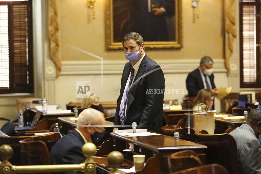House Ways and Means Chairman Murrell Smith, center, walks through the chamber during the House session on Wednesday, Jan. 27, 2021, in Columbia, S.C. The House gave key approval to a plan to alter how COVID-19 vaccines are distributed in South Carolina. (AP Photo/Jeffrey Collins)