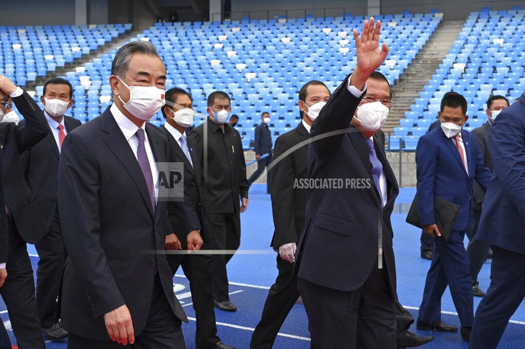 Tang Chhin Sothy Chinese Foreign Minister Wang Yi front left, accompanies by Cambodian Prime Minister Hun Sen, front right, walks around during a tour to the Morodok Techo National Stadium, as it was handed over to the Cambodian organizing committee of the Southeast Asian Games, in Phnom Penh, Cambodia, Sunday, Sept. 12, 2021. Wang is visiting Cambodia, where he met with Hun Sen and other officials to discuss COVID-19 and other regional issues. (Tang Chhin Sothy/Pool Photo via AP)