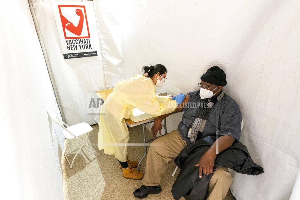 Mary Altaffer FILE - In this Jan. 23, 2021, file photo, registered Nurse Shyun Lin, left, gives Roberto Fisher, 72, the first dose of the COVID-19 vaccine at a pop-up vaccination site in the William Reid Apartments in the Brooklyn borough of New York. Coronavirus deaths and cases per day in the U.S. dropped markedly over the past couple of weeks but are still running at alarmingly high levels, and the effort to snuff out COVID-19 is becoming an ever more urgent race between the vaccine and the mutating virus. (AP Photo/Mary Altaffer, Pool, File)