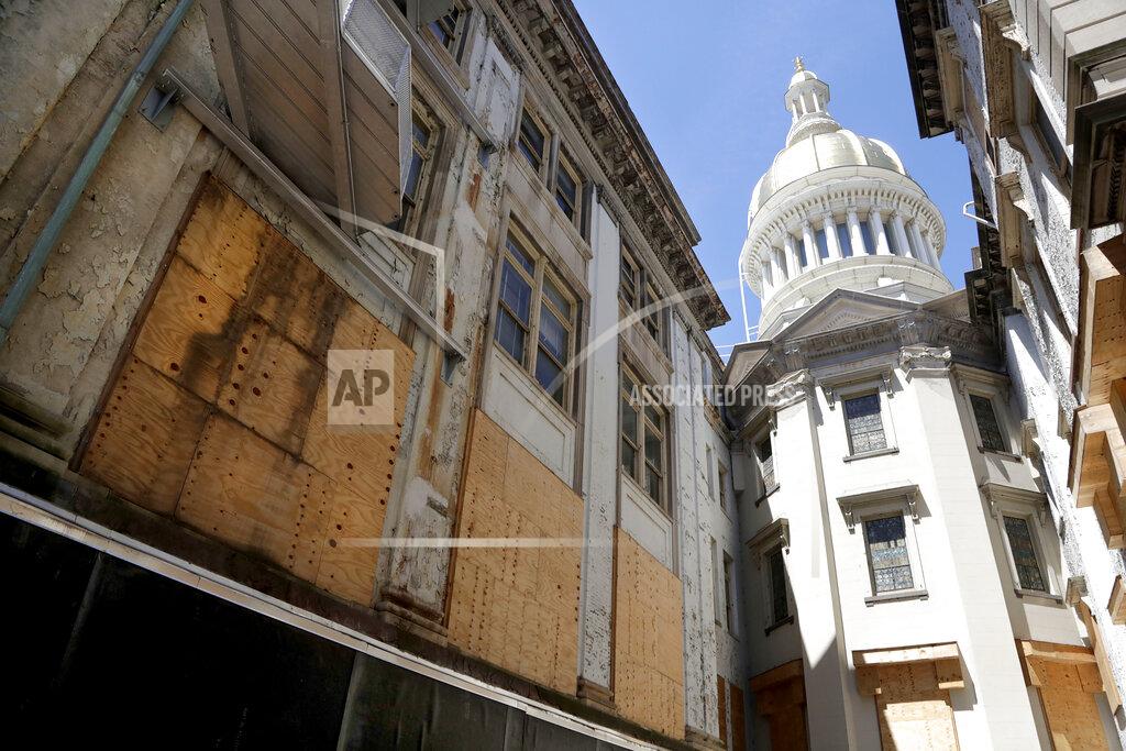 FILE - In this May 24, 2018, file photo, windows are seen boarded up during the renovation of the New Jersey Statehouse, in Trenton, N.J. The $300 million refurbishment that began soon after it was announced by former Gov. Chris Christie in late 2016 was supposed to take four years. In 2018, the completion date was expected to be 2022, and now Gov. Phil Murphy's administration says it'll be January 2023 before the renovation is done. (AP Photo/Julio Cortez, File)