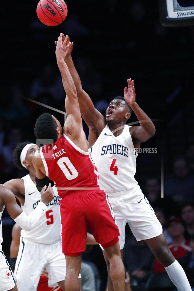 Kathy Willens Richmond forward Nathan Cayo (4) defends Wisconsin guard D'Mitrik Trice (0) during the second half of an NCAA college basketball game in the Legends Classic, Monday, Nov. 25, 2019, in New York. Richmond defeated Wisconsin 62-52. (AP Photo/Kathy Willens)