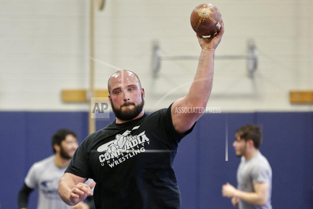 Nati Harnik In this March 2, 2020, photo, former Nebraska football player Tanner Farmer and current wrestler for Concordia University throws a football during warmups before practice in Seward, Neb. A year ago Farmer was thought to be on the rise as an NFL draft prospect. Now he is wrestling. (AP Photo/Nati Harnik)