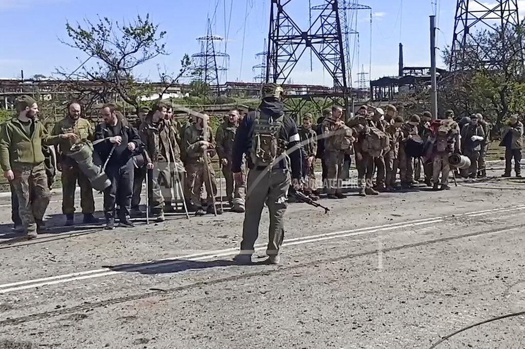 Uncredited In this photo taken from video released by the Russian Defense Ministry Press Service on Wednesday, May 18, 2022, Ukrainian servicemen stand in font of a Russian serviceman after they leaved the besieged Azovstal steel plant in Mariupol, Ukraine.(Russian Defense Ministry Press Service via AP)