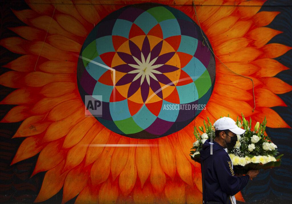 Fernando Llano A flower vendor wearing a face mask amid the spread of coronavirus walks outside the closed Jamaica flower market in Mexico City, Thursday, May 7, 2020. While some flower vendors with shops still open outside the market, the large wholesale flower market temporarily closed for one week on Thursday ahead of Mother’s Day, an effort by the city to keep the usual holiday crowds away. (AP Photo/Fernando Llano)