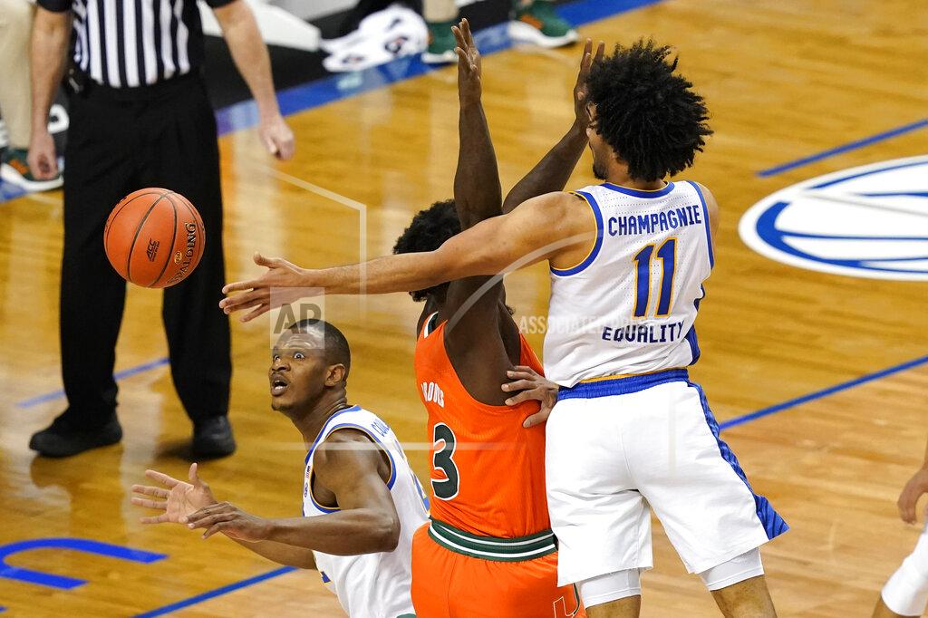 Gerry Broome Pittsburgh forward Justin Champagnie (11) passes to teammate Pittsburgh forward Abdoul Karim Coulibaly, left, as Miami center Nysier Brooks (3) defends during the first half an NCAA college basketball game in the first round of the Atlantic Coast Conference tournament in Greensboro, N.C., Tuesday, March 9, 2021. (AP Photo/Gerry Broome)