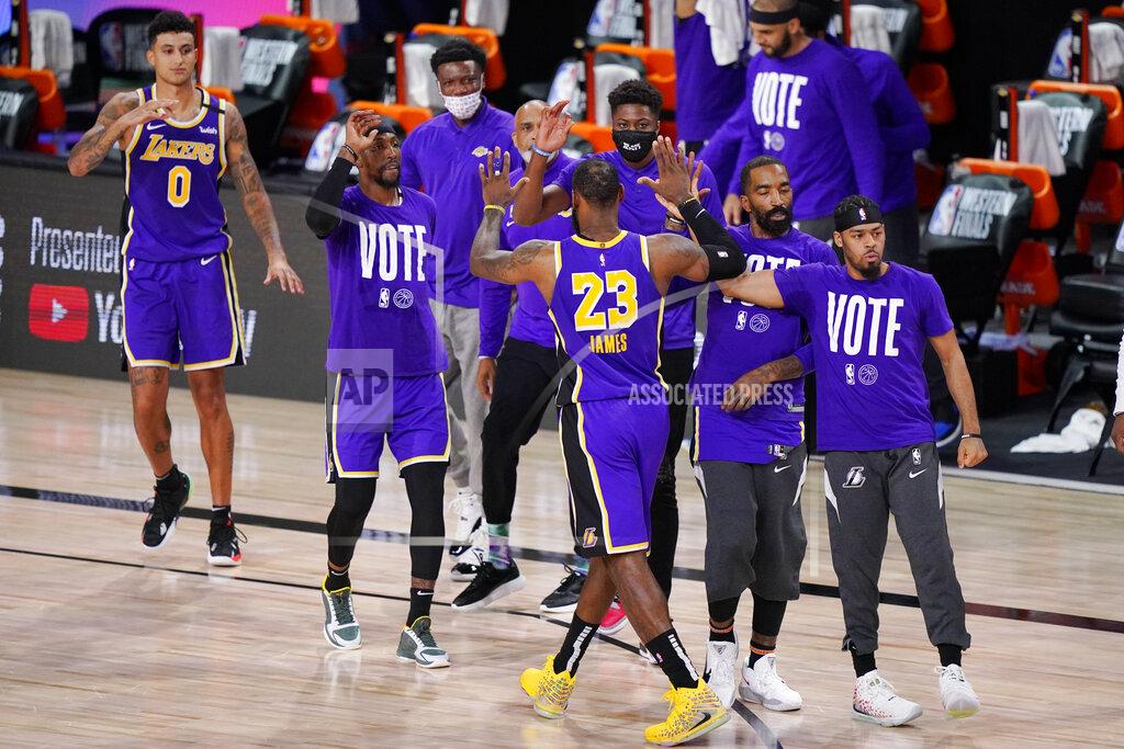 Mark J. Terrill Los Angeles Lakers' LeBron James (23) celebrates with teammates during a timeout in the final moments of an NBA conference final playoff basketball game against the Denver Nuggets Saturday, Sept. 26, 2020, in Lake Buena Vista, Fla. The Lakers won 117-107 to win the series 4-1. (AP Photo/Mark J. Terrill)