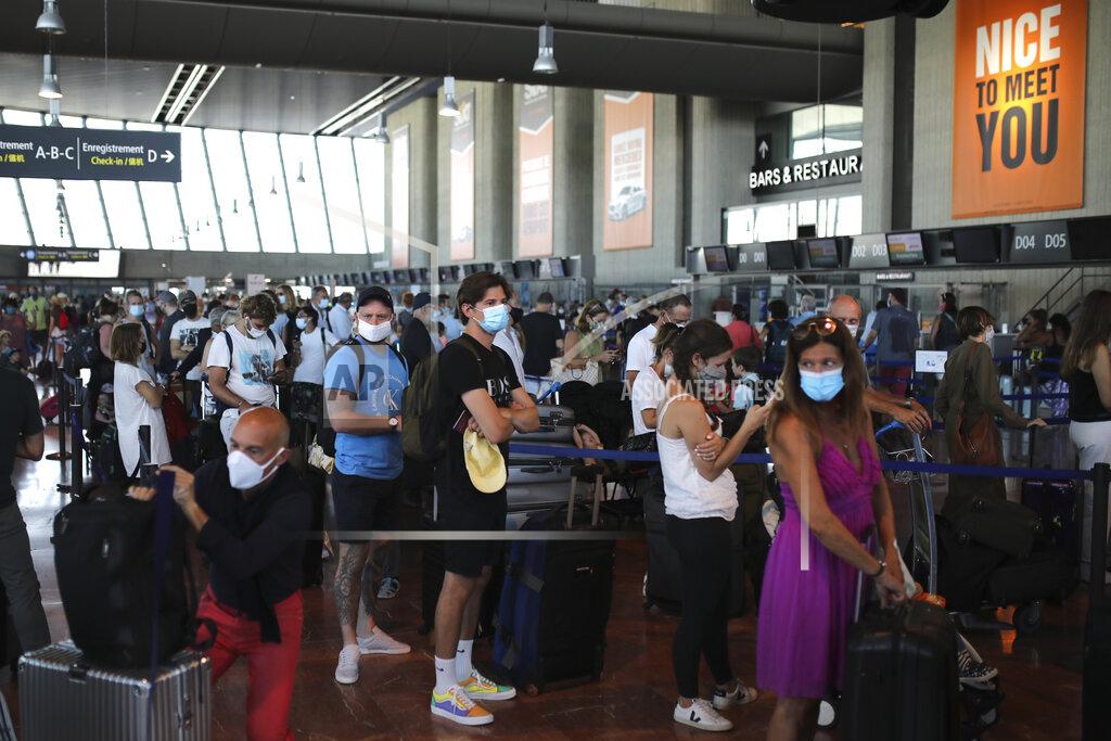 Daniel Cole People queue in line to check-in for a British Airways flight to Heathrow airport, Friday Aug.14, 2020 at Nice airport, southern France. British holidaymakers in France were mulling whether to return home early Friday to avoid having to self-isolate for 14 days following the U.K. government's decision to reimpose quarantine restrictions on France amid a recent pick-up in coronavirus infections. (AP Photo/Daniel Cole)