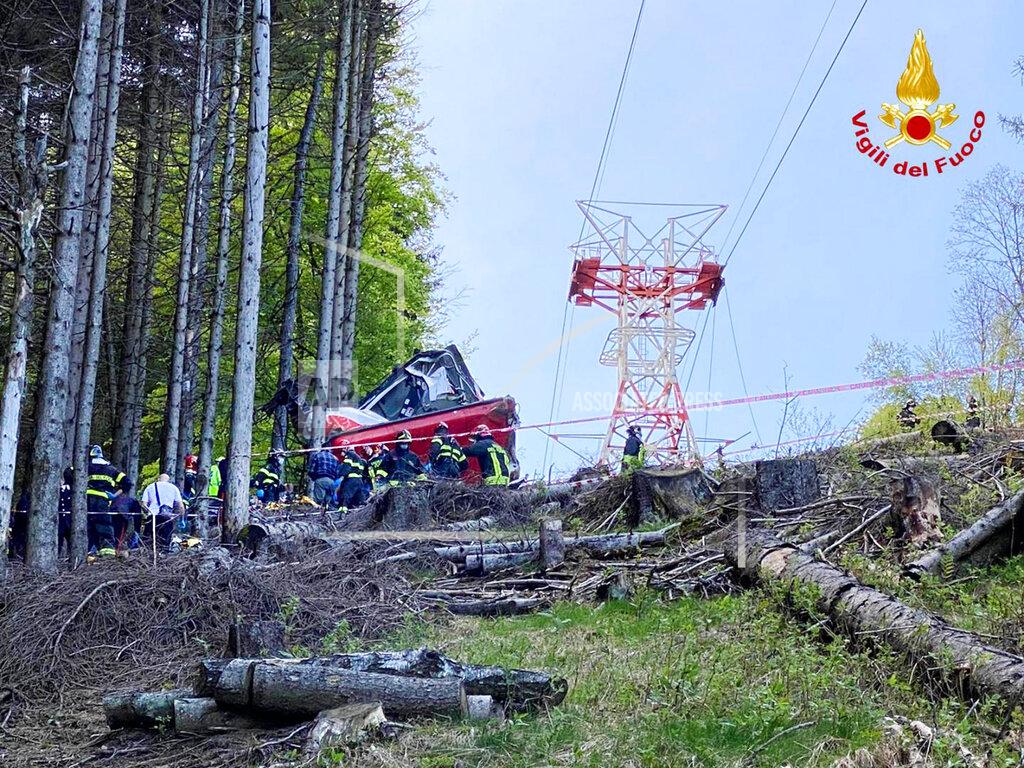 Uncredited Rescuers work by the wreckage of a cable car after it collapsed near the summit of the Stresa-Mottarone line in the Piedmont region, northern Italy, Sunday, May 23, 2021. A cable car taking visitors to a mountaintop view of some of northern Italy's most picturesque lakes plunged to the ground Sunday, killing at least nine people and sending two children to the hospital, authorities said. (Italian Vigili del Fuoco Firefighters via AP)