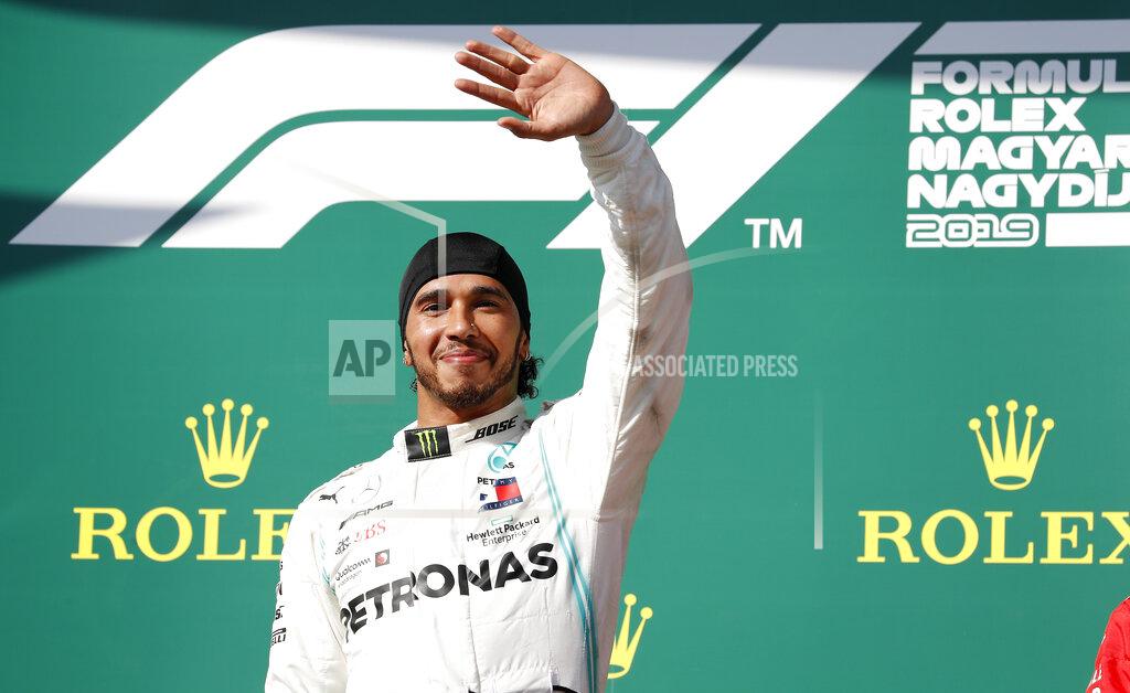 Laszlo Balogh Mercedes driver Lewis Hamilton of Britain celebrates on the podium after winning the Hungarian Formula One Grand Prix at the Hungaroring racetrack in Mogyorod, northeast of Budapest, Hungary, Sunday, Aug. 4, 2019. (AP Photo/Laszlo Balogh)