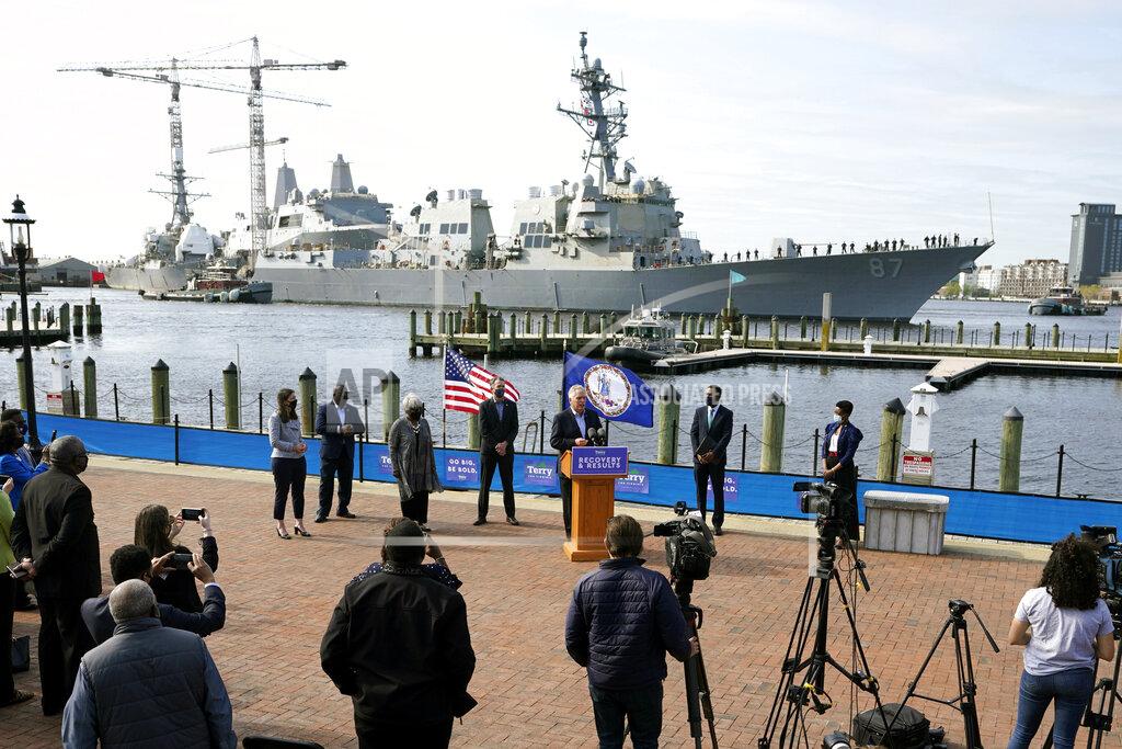 Steve Helber The USS Mason, an Arleigh Burke-class destroyer, glides past a news conference as former Gov. and Democratic gubernatorial candidate, Terry McAuliffe, at podium speaks, at Waterside in Norfolk, Va., Thursday, April 8, 2021. Virginia Gov. Ralph Northam endorsed McAuliffe for governor. (AP Photo/Steve Helber)