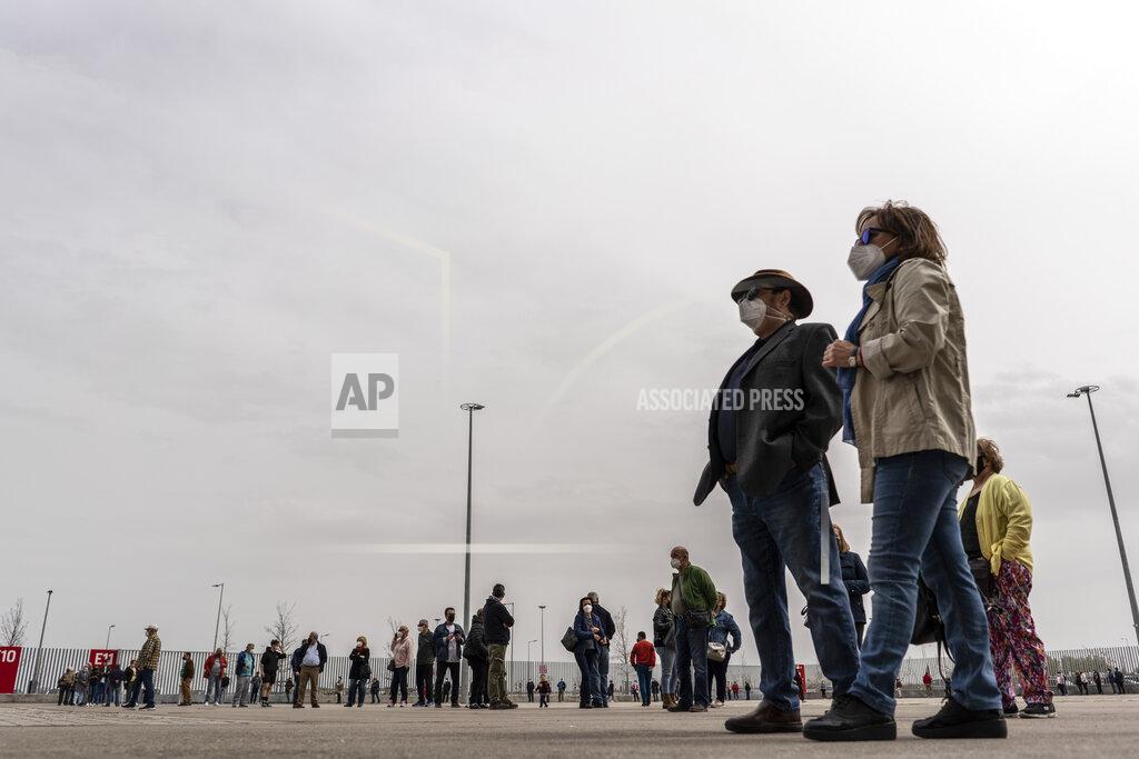 Olmo Calvo People queue to be vaccinated against COVID-19 at the Wanda Metropolitano stadium, Madrid, Spain, March 30, 2021. Spain is trying to stamp out a new wave of COVID-19 among its youth thanks to a robust vaccination program that is widely supported. Spain like the rest of the European Union got off to a slow start to compared to the United States and Britain when the first vaccines were released. But it has quickly made up ground once deliveries by drug makers started flowing. (AP Photo/Olmo Calvo)