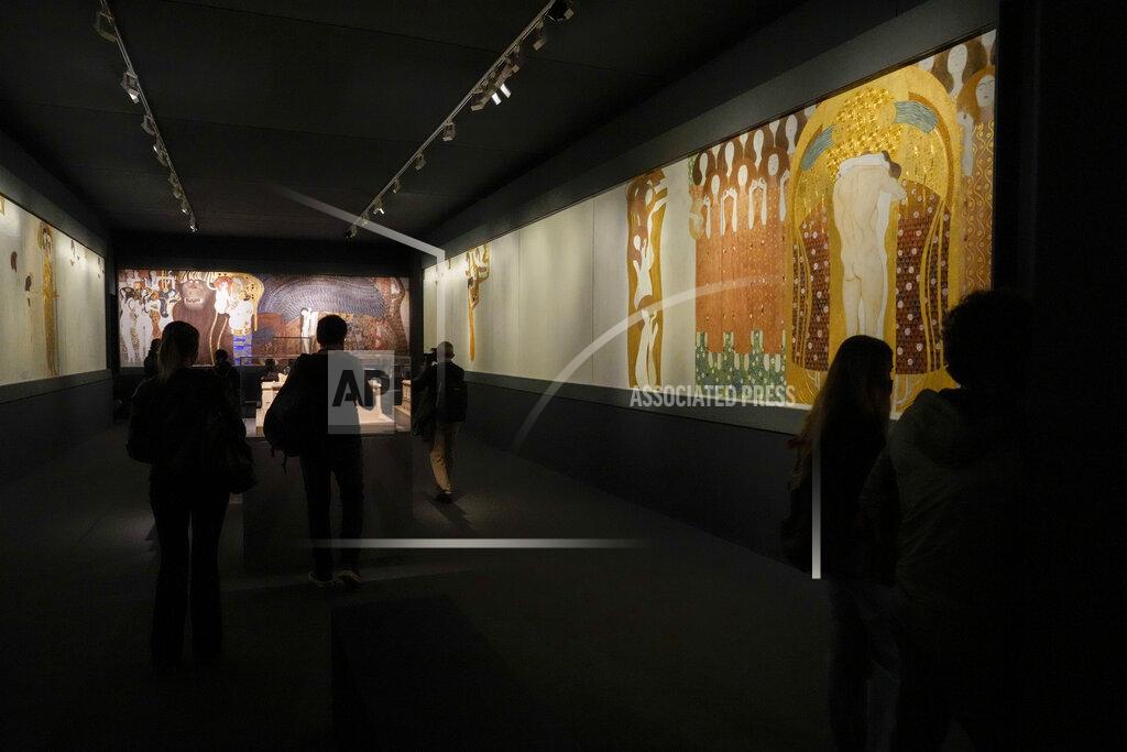 Andrew Medichini People admire Gustav Klimt's painting "The Beethoven Frieze" (1902) on display at the exhibition "Klimt. The Secession and Italy" at the Museum of Rome, in Palazzo Braschi, Rome, during a press preview, Tuesday, Oct. 26, 2021. The exhibition, that explores Klimt's period in Italy, will be open to visitors from Oct.27, 2021 to March 27, 2022. (AP Photo/Andrew Medichini)