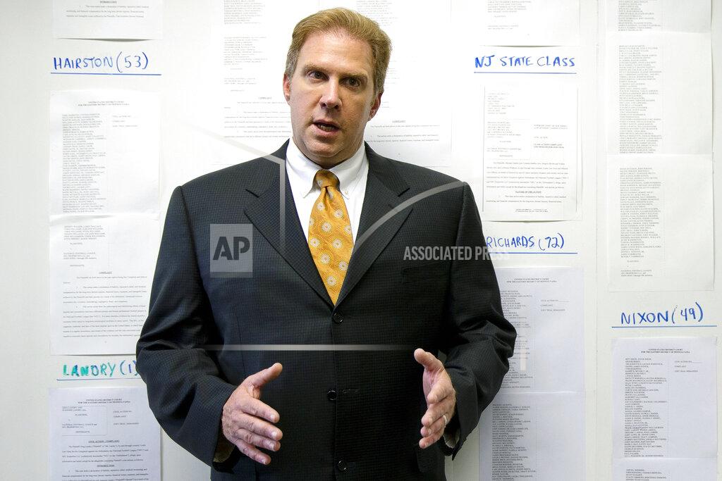 FILE - In this July 18, 2014, file photo, lawyer Craig Mitnick speaks as he stands in front of a photograph that lists some of the approximately 1,400 players in NFL concussion litigation he represented, in Haddonfield, N.J. After several years of infighting over $112 million in legal fees in the NFL concussion case, a federal appeals court has approved a plan to give nearly half the money to New York-based Seeger Weiss. The decision Thursday, May 7, 2020, grants New York-based Seeger Weiss firm over $51 million, more than 10 times the amount of any other firm, including the lawyers who filed the first cases in 2012. Mitnick, whose split of the legal fees was left at about $675,000, felt the appeals court did not sufficiently explain its reasoning. Oral arguments in the case were cancelled amid the COVID-19 courthouse shutdown, he said. (AP Photo/Matt Rourke, File)