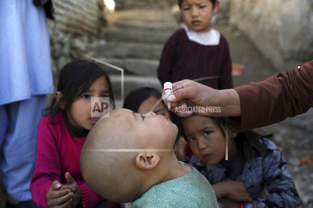 Rahmat Gul Shabana Maani, gives a polio vaccination to a child in the old part of Kabul, Afghanistan, Monday, March 29, 2021. Afghanistan is trying to inoculate millions of children against polio after pandemic lockdowns stalled the effort to eradicate the crippling disease. But the recent killing of three vaccinators points to the dangers facing the campaign as turmoil grows in the country. (AP Photo/Rahmat Gul)