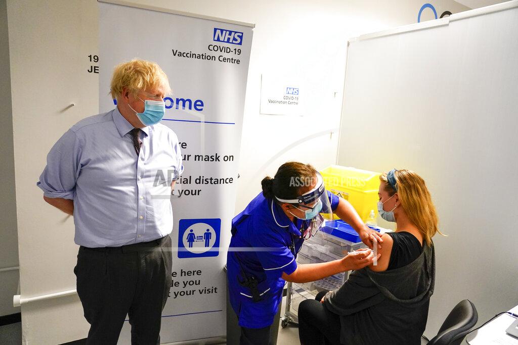 Alberto Pezzali FILE - In this June 21, 2021, file photo, Britain's Prime Minister Boris Johnson, left watches as a woman receive her COVID-19 vaccine, as he visits a vaccination center at the StoneX Stadium, home of the rugby club Saracens, in North London. Britain's Conservative government is hoping a combination of relatively high vaccination rates and common-sense behavior will keep a lid on coronavirus infections this fall and winter and avoid the need for restrictive measures. (AP Photo/Alberto Pezzali, Pool, File)