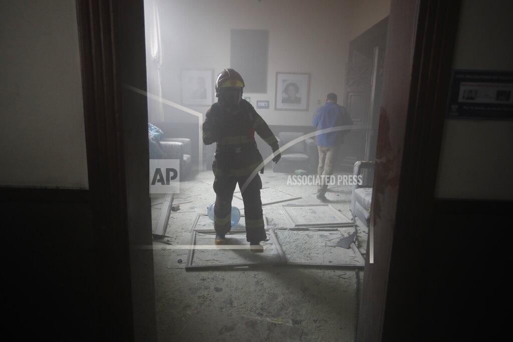 Moises Castillo A firefighter walks inside the Congress building after protesters set a part of the building on fire, in Guatemala City, Saturday, Nov. 21, 2020. Hundreds of protesters were protesting in various parts of the country Saturday against Guatemalan President Alejandro Giammattei and members of Congress for the approval of the 2021 budget that reduced funds for education, health and the fight for human rights. (AP Photo/Moises Castillo)