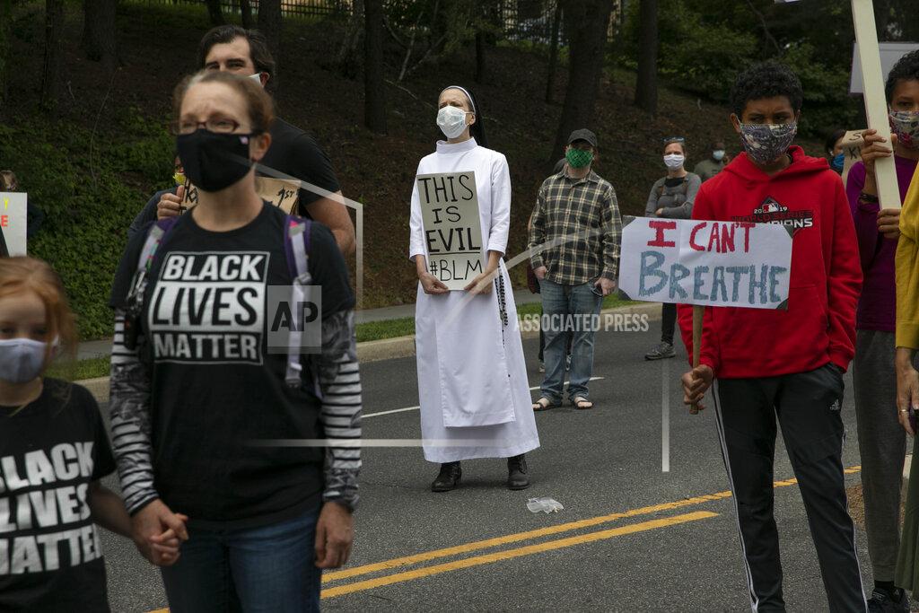 Jacquelyn Martin Sister Quincy Howard, center, a Dominican nun, protests the arrival of President Donald Trump to the Saint John Paul II National Shrine, Tuesday, June 2, 2020, in Washington. Many demonstrators present said they were dismayed when Trump staged a visit to the historic St. John's Church across from the White House and held up a Bible after authorities had cleared the area of peaceful protesters. "I'm here in protest," says Howard, "of violence, of inciting violence, of systemic racism and using religion as a shield." Protests continue over the death of George Floyd, who died after being restrained by Minneapolis police officers. (AP Photo/Jacquelyn Martin)