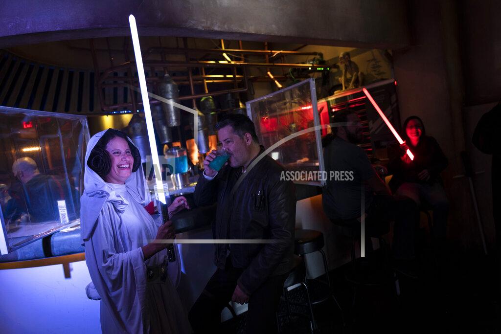 Jae C. Hong Elen Monocroussos, left, and boyfriend, James Stevens, are dressed in Star Wars costumes as they celebrate the Star Wars Day at Scum and Villainy Cantina, a geekbar located on Hollywood Blvd, in Los Angeles, Tuesday, May 4, 2021. California has the lowest infection rate in the country. Los Angeles County, which is home to a quarter of the state's nearly 40 million people and has endured a disproportionate number of the state's 60,000 deaths, didn't record a single COVID-19 death Sunday or Monday, which was likely due to incomplete weekend reporting but still noteworthy. (AP Photo/Jae C. Hong)