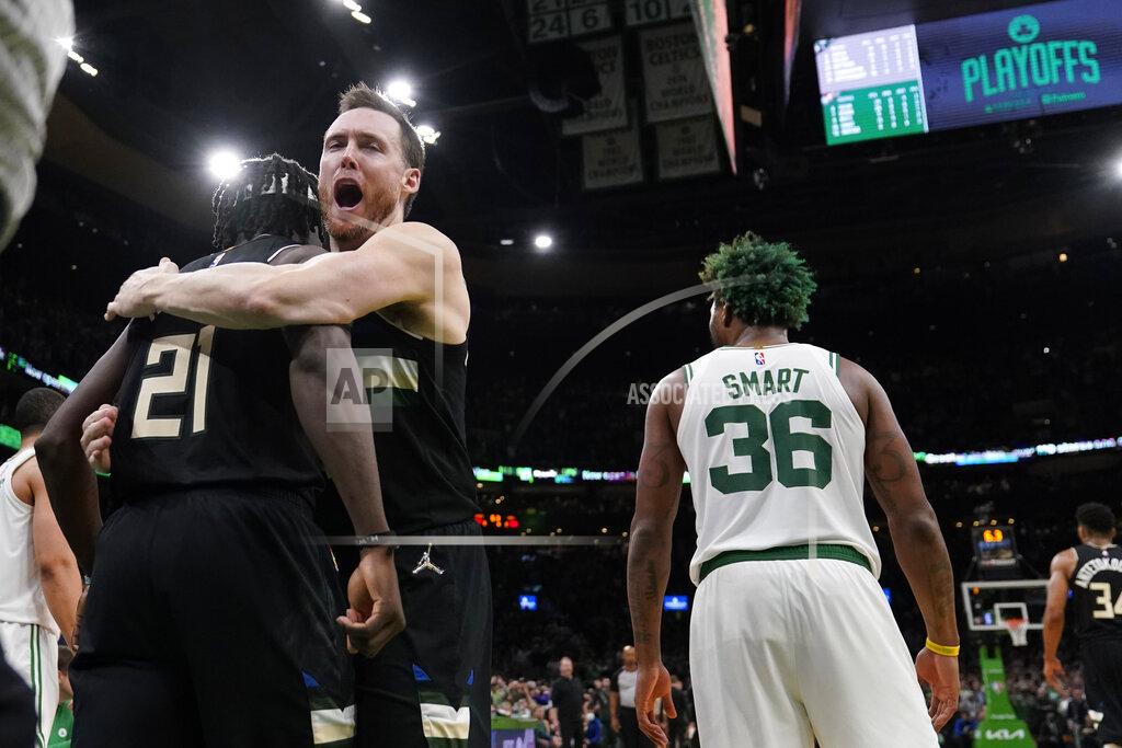 Charles Krupa Milwaukee Bucks guard Jrue Holiday (21) is embraced by Pat Connaughton while celebrating after blocking a shot by Boston Celtics guard Marcus Smart (36) in the final seconds of play during the second half of Game 5 of an Eastern Conference semifinal in the NBA basketball playoffs, Wednesday, May 11, 2022, in Boston. The Bucks won 110-107. (AP Photo/Charles Krupa)